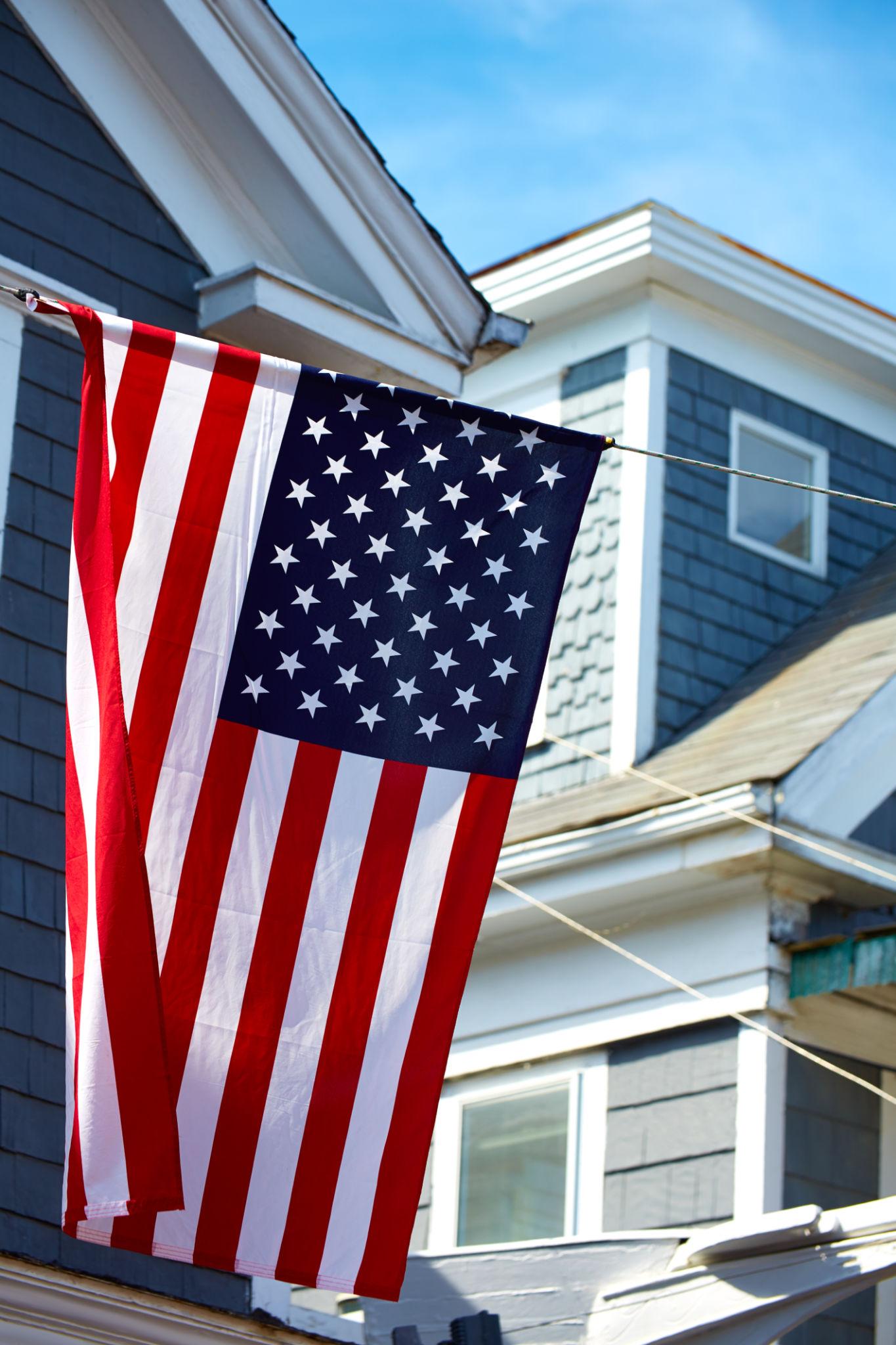 Luxury Cape Cod House with American Flag and New Gutters